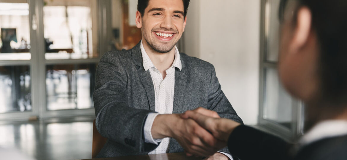 business-career-placement-concept-happy-caucasian-man-30s-rejoicing-shaking-hands-with-employee-when-was-recruited-during-interview-office