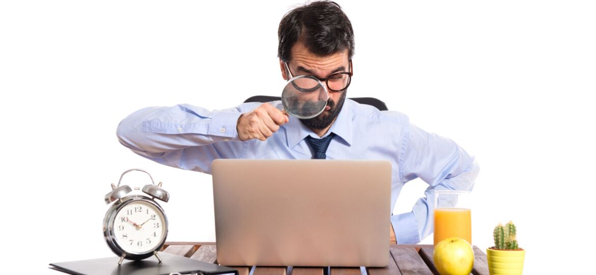 Businessman in his office with magnifying glass