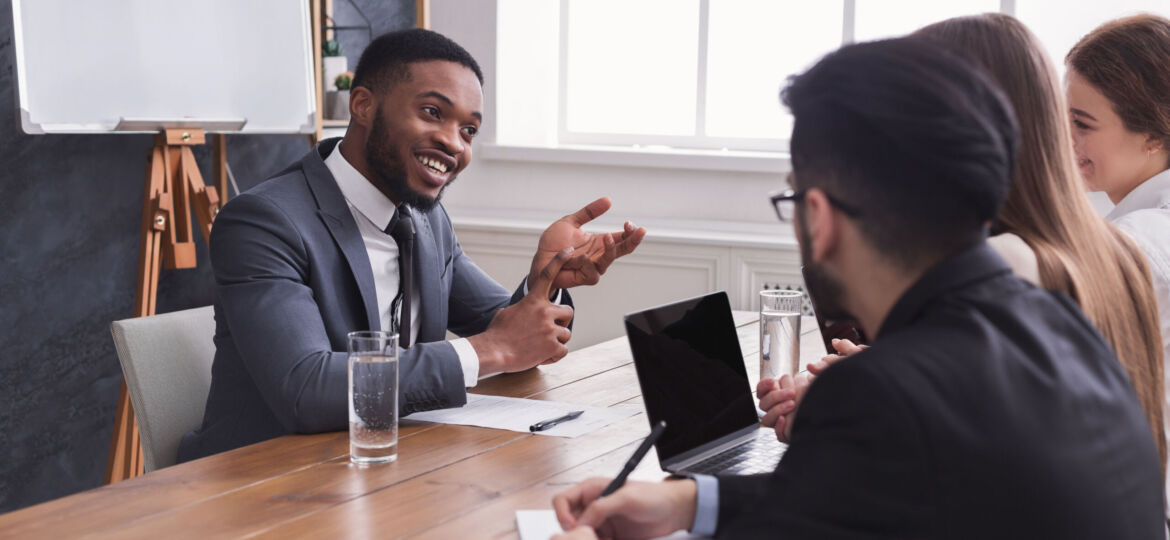 Cheerful african-american applicant talking at job interview