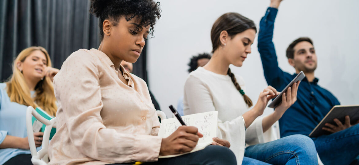 Group of young people sitting on conference together.