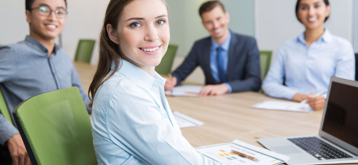 Smiling young businesswoman sitting in boardroom