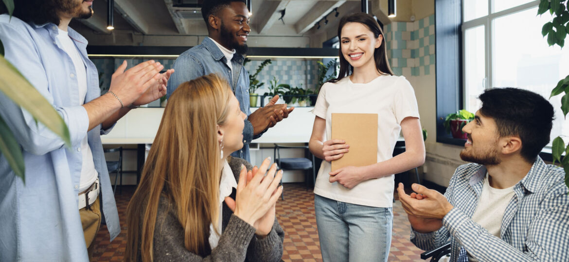 Group of young business people applaud their female colleague after presentation