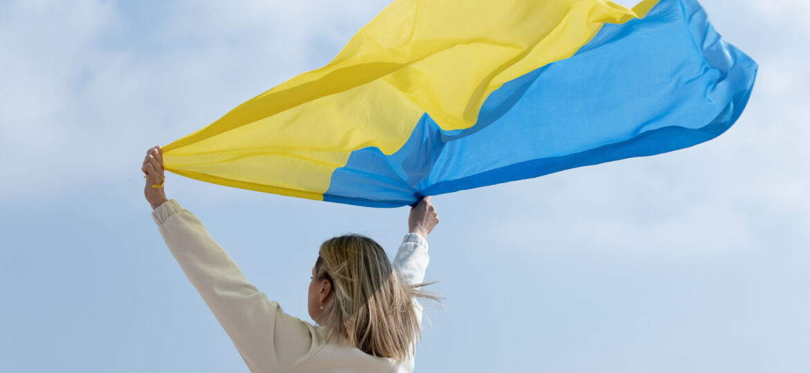medium-shot-woman-holding-ukranian-flag