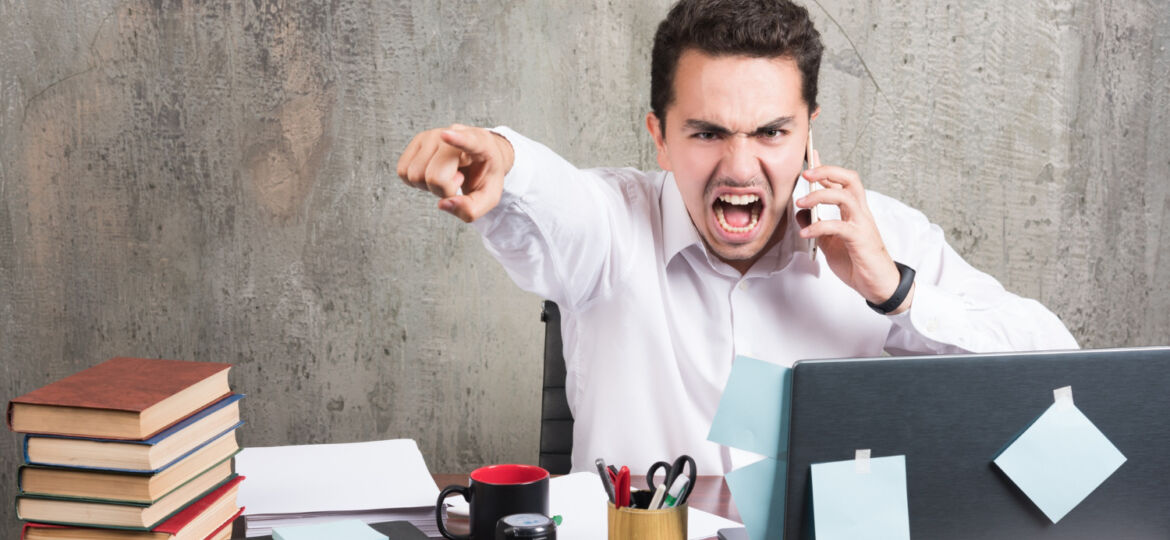 angry-businessman-talking-with-telephone-office-desk
