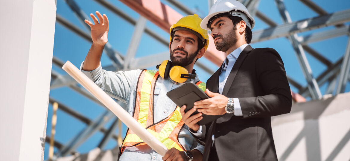 civil-engineer-construction-worker-manager-holding-digital-tablet-blueprints-talking-planing-about-construction-site-cooperation-teamwork-concept
