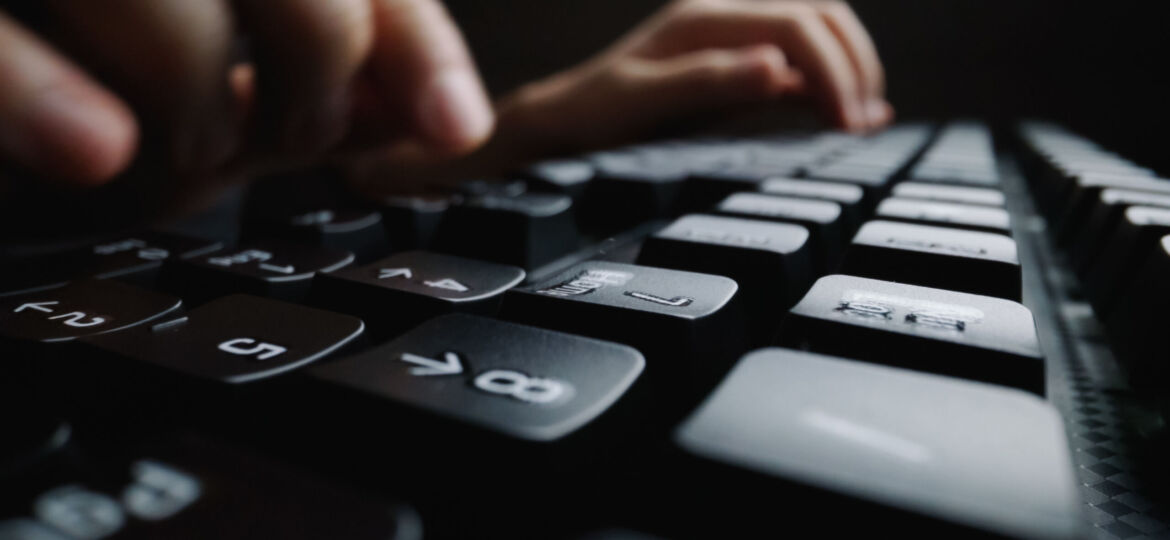 Close-up soft-focus finger typing on keyboard.