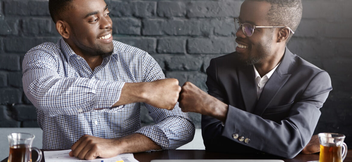 Two black men fist bumping because they found their perfect job