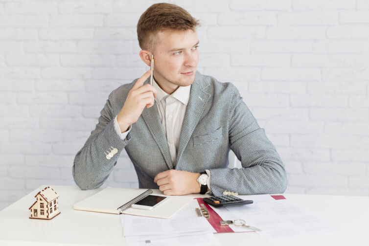 pensive-realtor-sitting-office