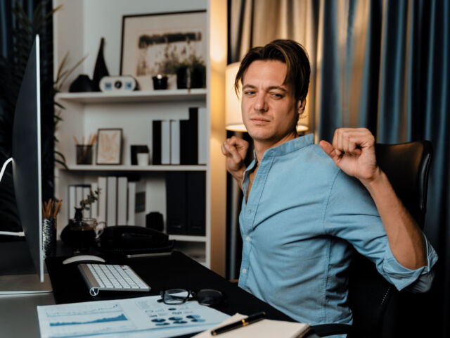 Sales manager working with stretching manner in working at night. Pecuniary.