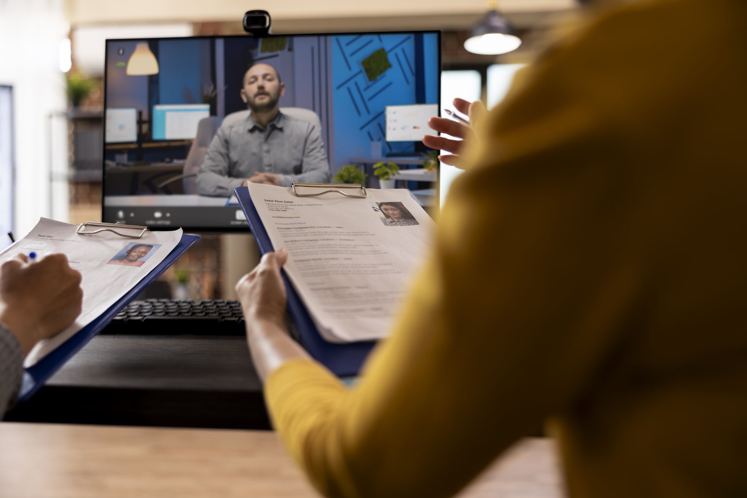 Hiring manager reviewing a candidate's resume during a remote job interview